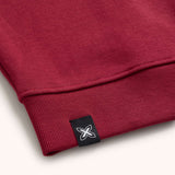 Sudadera Munich Essentials cuello redondo burdeos wine – Detalle bajo canalé y etiqueta Munich