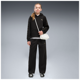 Pantalón Puma junior negro de pernera amplia, detalle frontal sobre modelo
