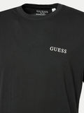 Detalle de la etiqueta Guess de algodón orgánico en el cuello de la camiseta negra
